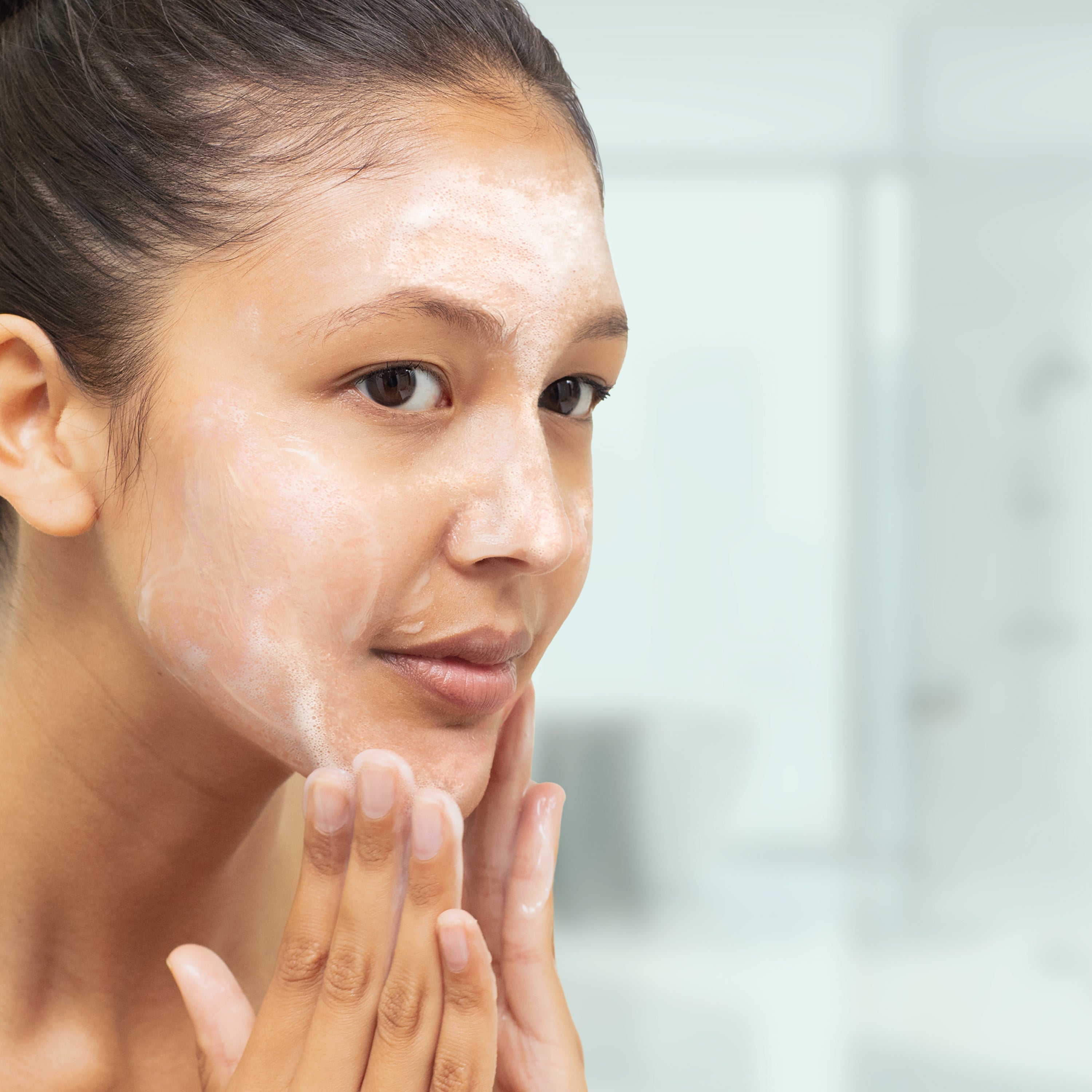woman washing her face to help with acne prevention